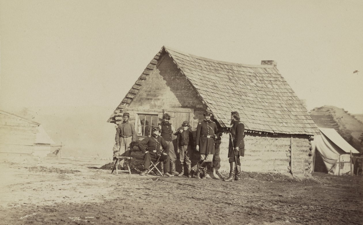 1861年至1865年，一群士兵和两名年轻人，一名是非裔美国人，站在小木屋的外面 作者 美国摄影师