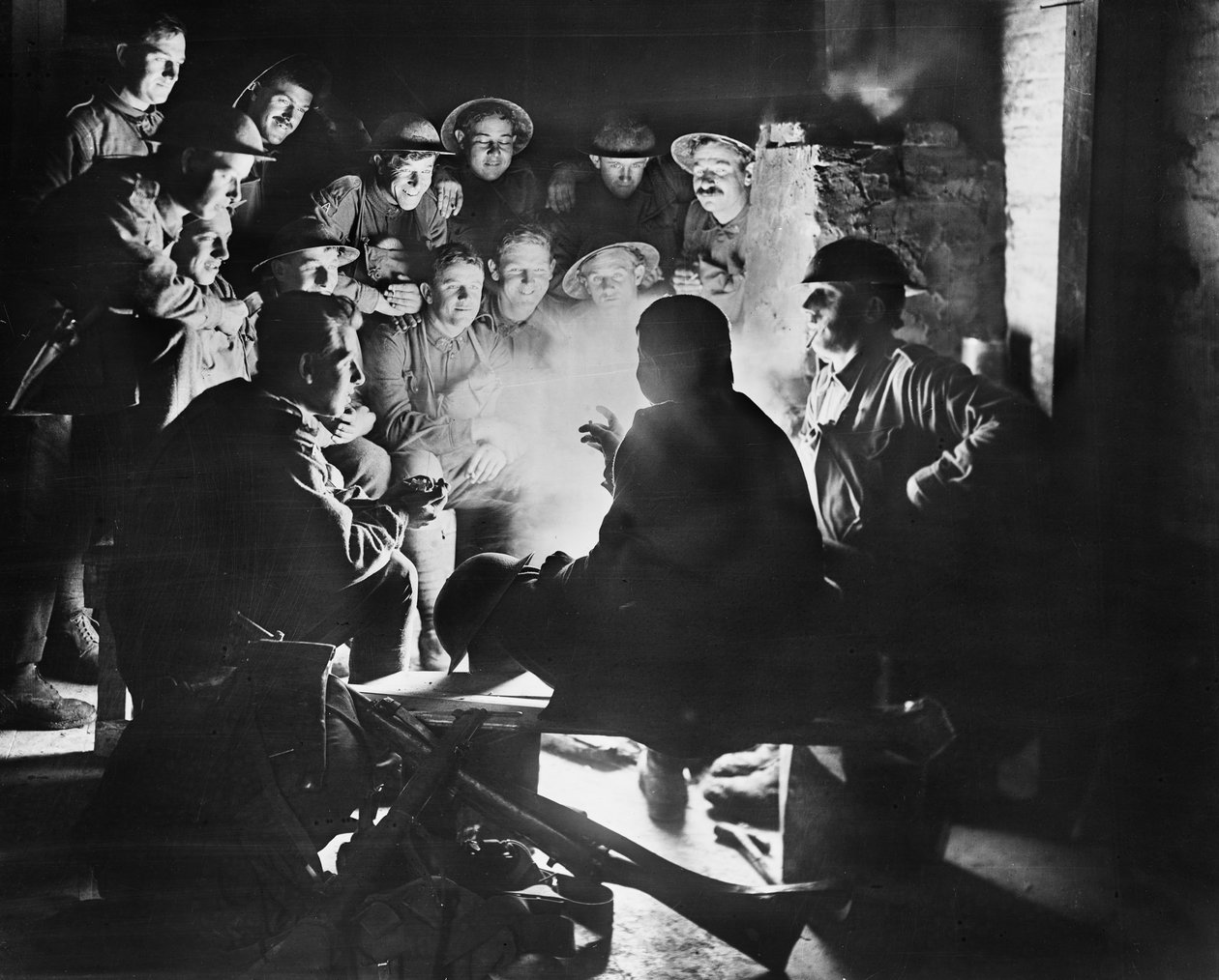 1917年10月28日，第一届澳大利亚轻型水泥砂浆电池组成员，第一澳大利亚分部在Ypres的一个防空小屋周围的一场火灾中听取其中一名同志的最新消息（bw pho） 作者 澳大利亚摄影师