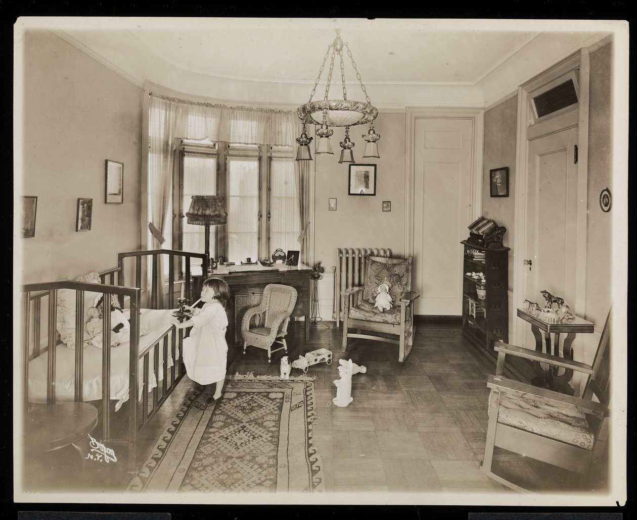 一个女孩拿着蜡烛，爬进婴儿床，在AC Cronin住宅的卧室，1915-16（银色明胶打印） 作者 拜伦公司