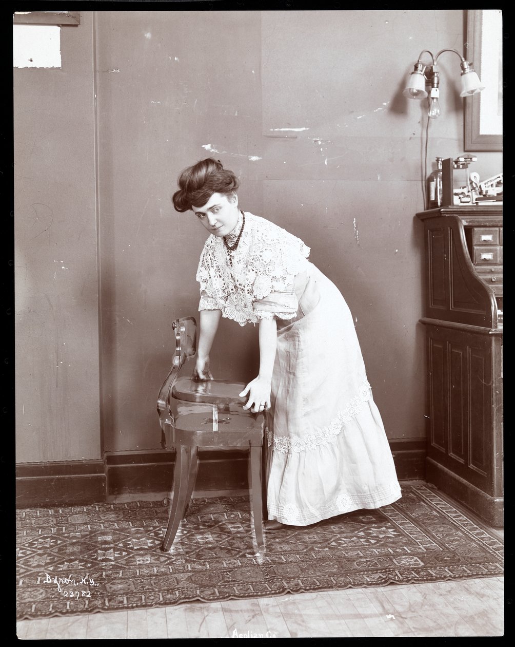一位女士在1906年或1907年纽约Aeolian公司展示一把特殊椅子（银色明胶印刷品） 作者 拜伦公司