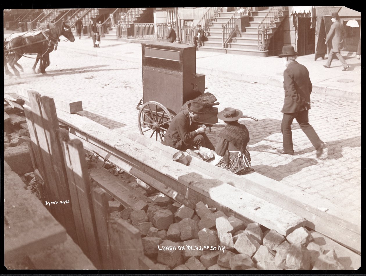 街头风琴师和一名妇女在1898年纽约西42街吃午餐的视图（银色明胶打印） 作者 拜伦公司