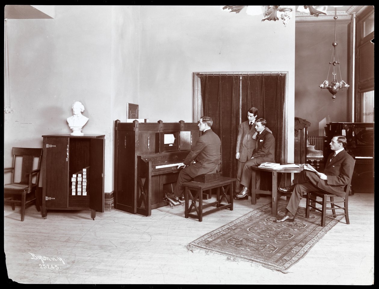 四名男子，一名演奏H. Bruman Co.弹奏钢琴，1907年（银色明胶印刷） 作者 拜伦公司