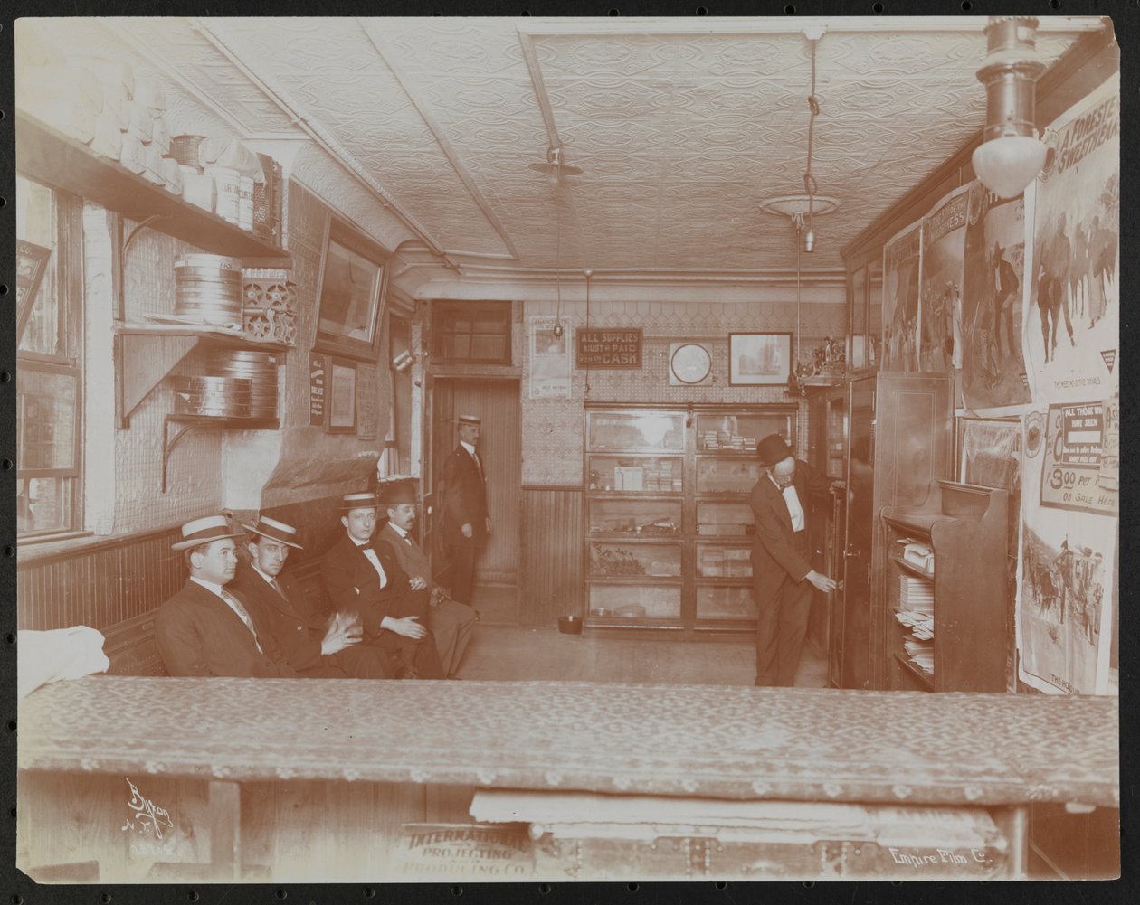 Empire Film Co (possibly at Broadway and 55th Street) with movie posters on wall and customers waiting 作者 拜伦公司