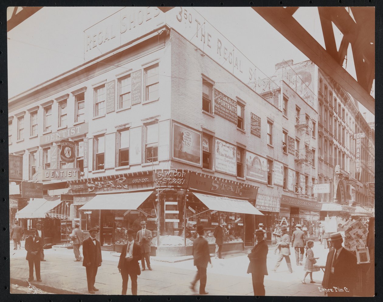 South-west corner of 14th Street and 3rd Avenue showing the Star Candies store, a dentist, the Regal Shoe store and the Empire Film Co. with pedestrians, billboards and a girder of the 3rd Avenue elevated railroad visible, c.1905 (b/w photo) 作者 拜伦公司