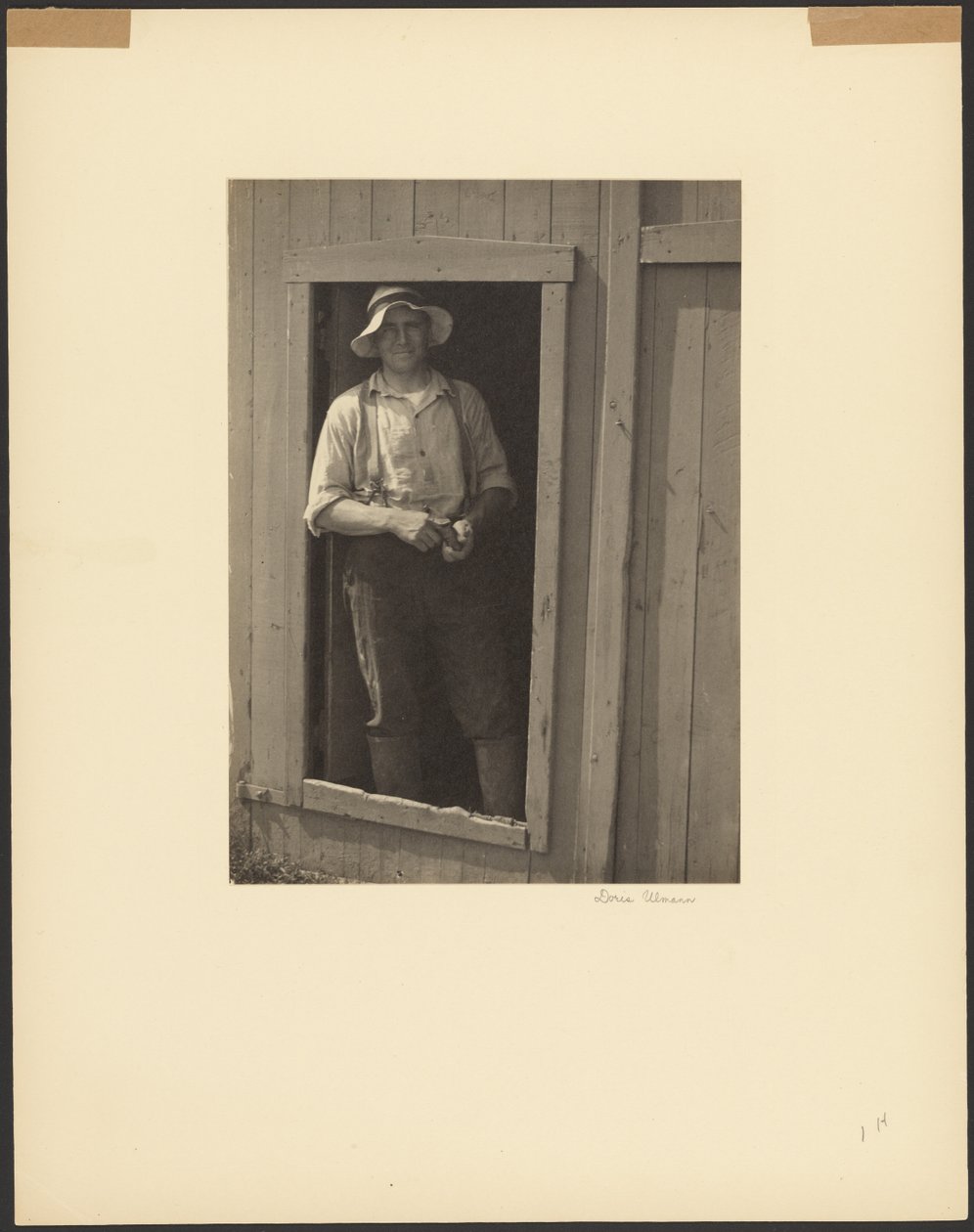 [一个戴草帽的男人站在谷仓门口 手里拿着烟袋] 作者 多丽丝·乌尔曼（Doris Ulmann）