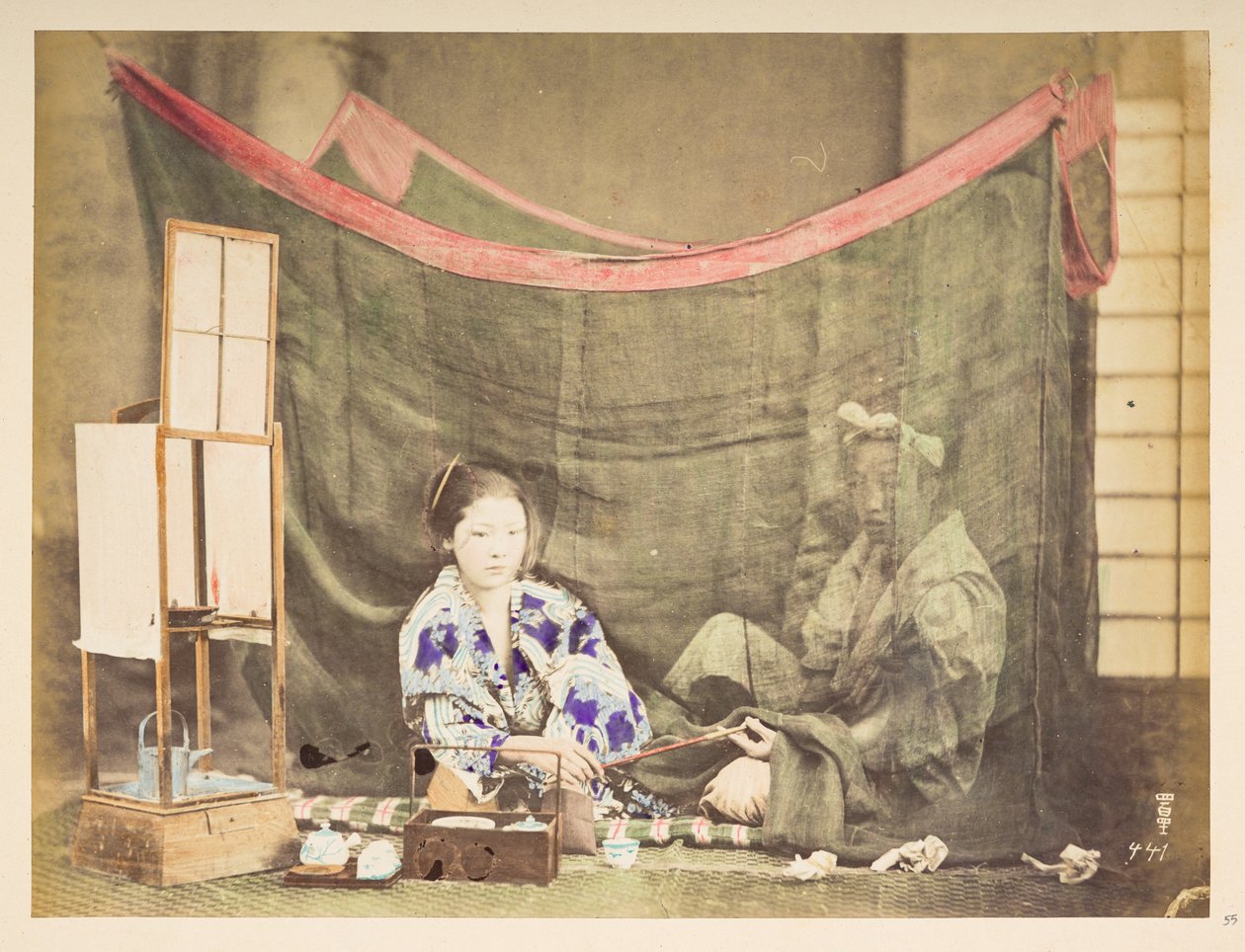 悠闲的日本夫妇，日本年轻女子的工作室场景，她坐在一旁，身边摆放着泡茶的器具，将烟斗递给坐在她身后的男子，男子被亚麻蚊帐遮挡，摄影师：卢卡斯收藏，未知 作者 英国摄影师