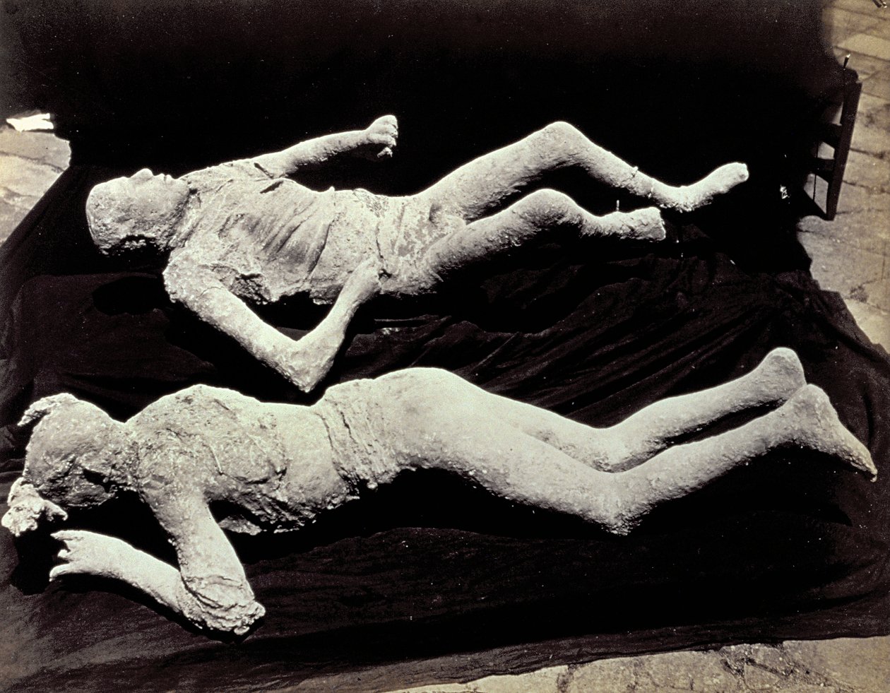 Two casts of human figures from the excavations of Pompeii. The exhibits were placed on black cloth in order to photograph them 作者 乔治·夏
