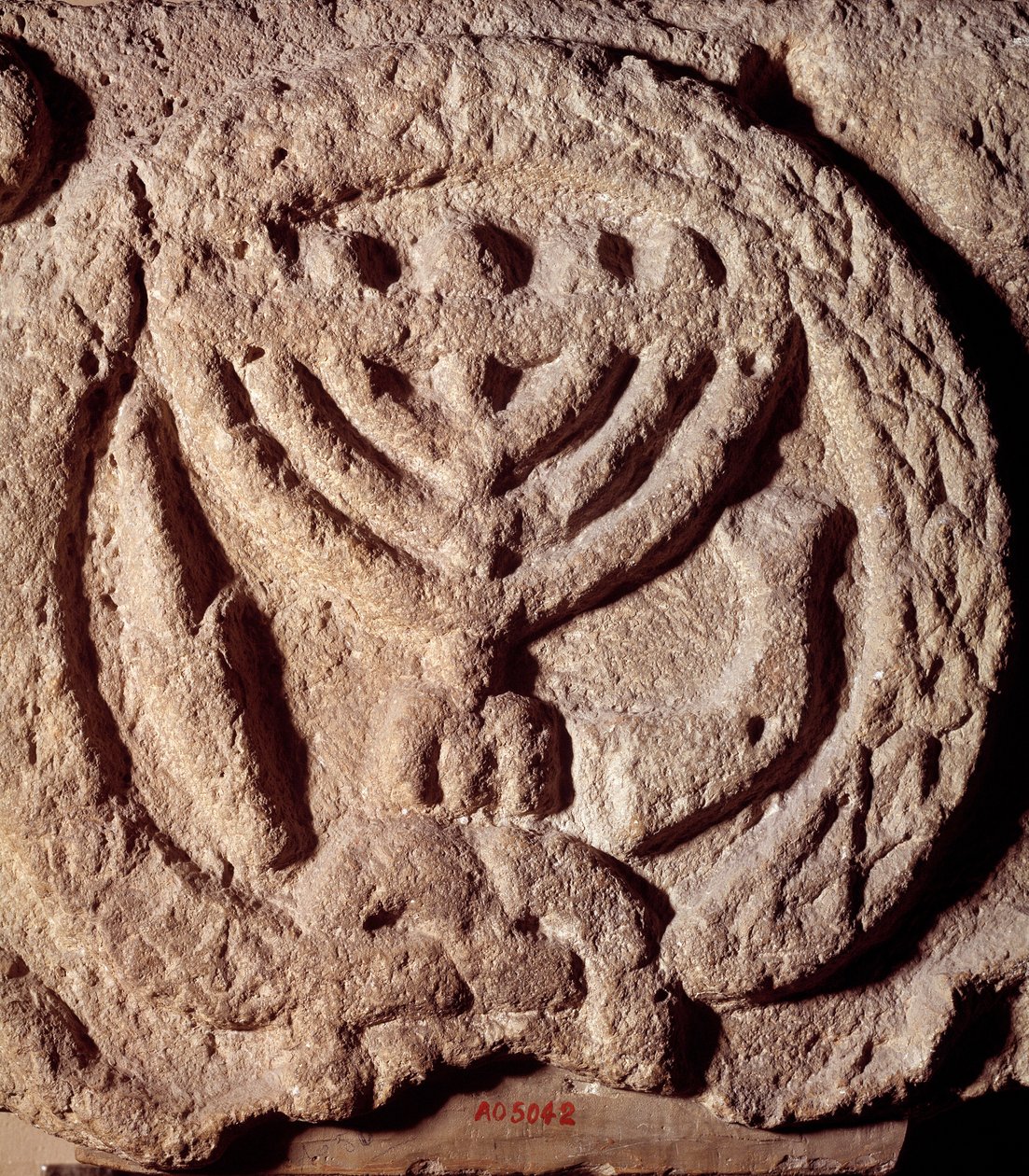 犹太教：犹太教堂玄武岩中的建筑元素，装饰有七枝烛台（Menora 或 Menorah）、棕榈树和喇叭。 来自外约旦。 大约公元 100 年。 巴黎，卢浮宫博物馆 作者 犹太学校