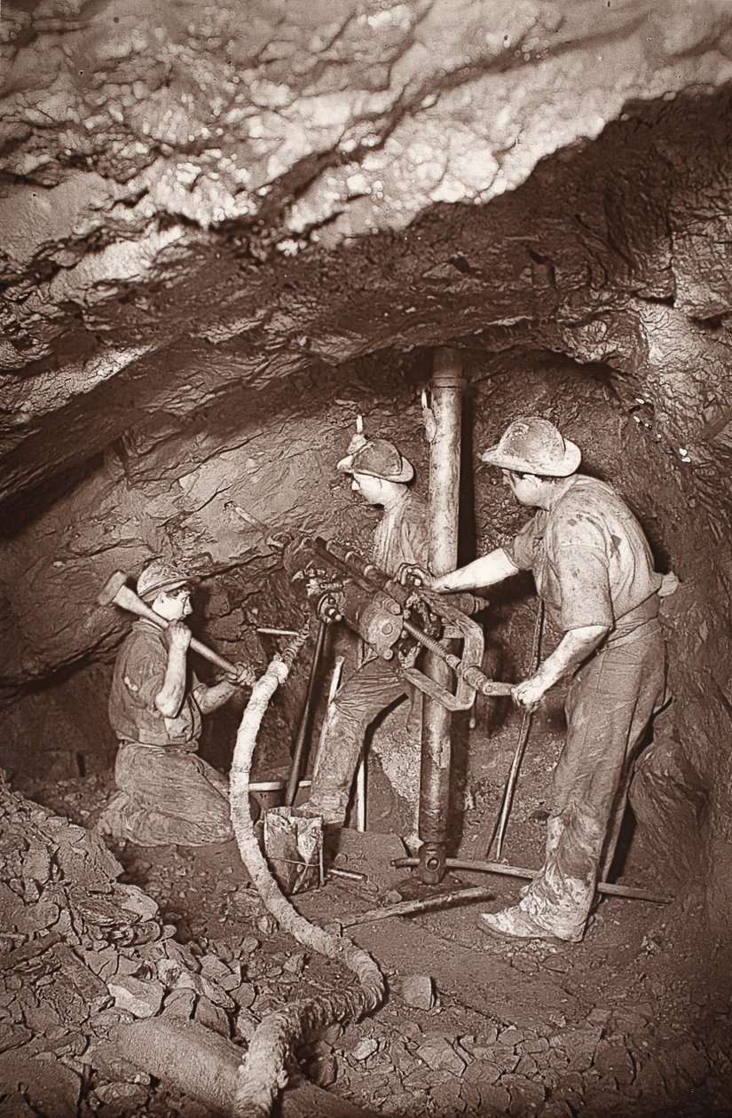 东池矿井的凿岩机末端，插图来自 J.C. Burrows 和 William Thomas 所著的《Mongst mines and miners, or Underground Scenes by Flash-Light》，1893 年出版（棕褐色照片）。1893 年（棕褐色照片） 作者 约翰·查尔斯·伯罗