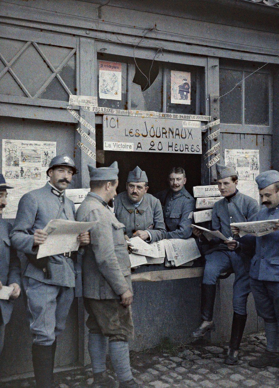 1917年9月6日，法国士兵在法国Nord-Pas-de-Calais地区北部Rexpoede的一个售货亭购买和阅读报纸（彩色照片） 作者 保罗·卡斯特尔瑙