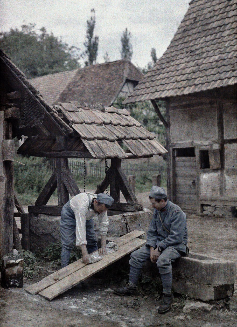1917年6月21日，法国阿尔萨斯省Haut-Rhin省Gildwiller镇附近一座农舍附近的喷泉水槽上，两名法国士兵正在照看他们的洗衣房。 作者 保罗·卡斯特尔瑙
