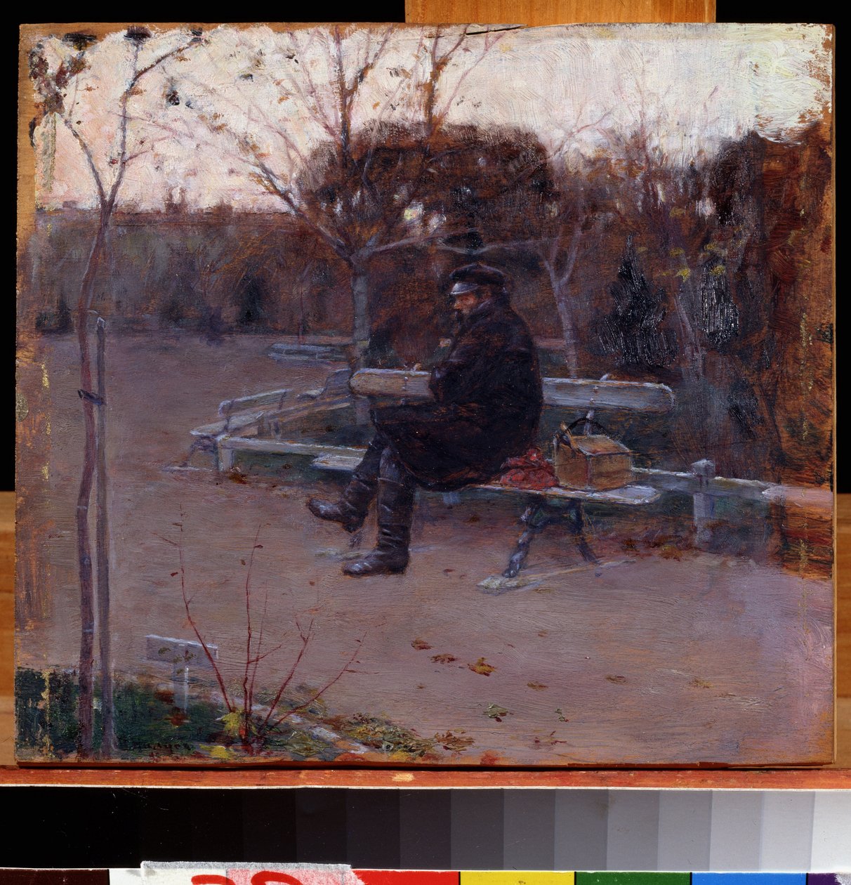 Sur le boulevard (On the Boulevard). Un homme seul, assis sur un banc dans le froid, pres de lui, un baluchon et une boite a outils. Peinture de Pyotr Alexandrovich Nilus (Pierre Nilous) (Nilouss) (1869-1940/1943), huile sur toile 作者 彼得·亚历山德罗维奇·尼鲁斯