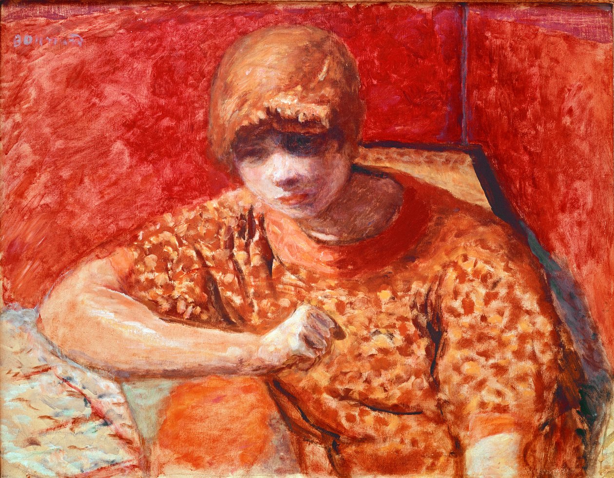 橙色上衣 年轻梦幻的女人坐在红色背景上有一张桌子。 Pierre Bonnard (1867-1947) 的画作，1913 年昏暗。 52x67 厘米巴黎，私人收藏 作者 皮埃尔·邦纳德