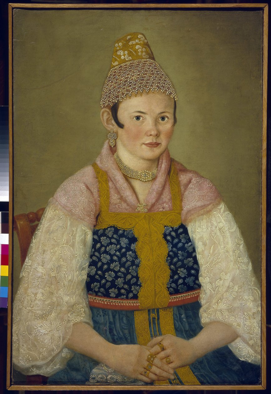 戴传统 Kokoshnik 头饰的商人妻子肖像。(戴 Kokoshnik Kabluchok 头饰的商人妻子肖像）。她还穿着绣有刺绣的俄罗斯传统服装（sarafane），上身穿有花边袖子的上衣，头戴头饰。 作者 学校俄语