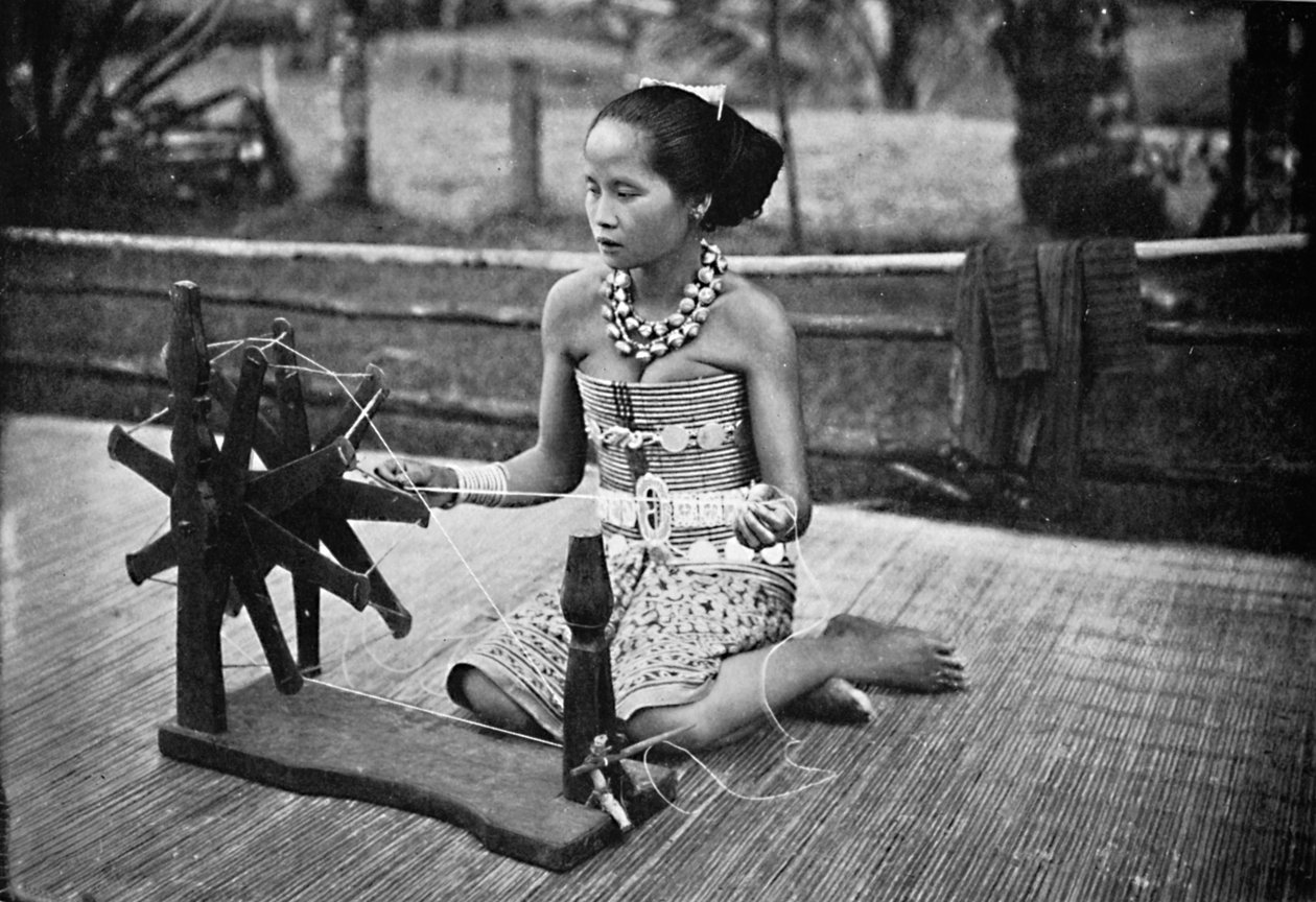 1902年，一个戴雅克女孩坐在纺车上 作者 不明
