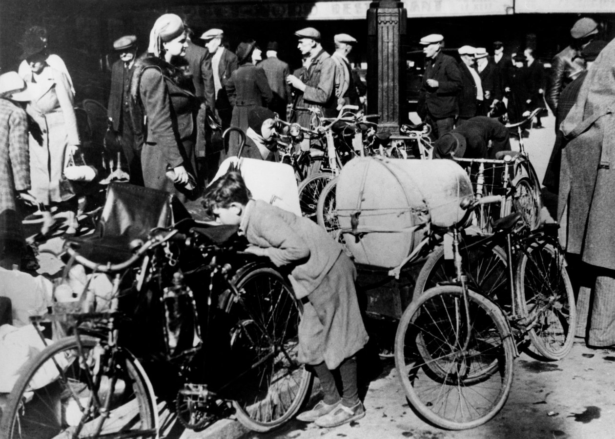 1940年7月，比利时难民在巴黎北火车站（Gare du Nord）外面带着自行车和财物 作者 不明