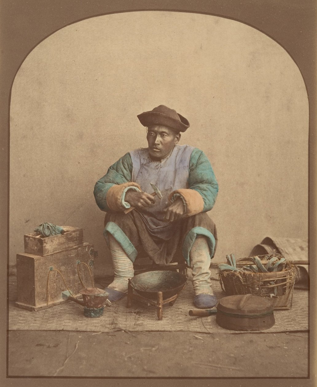 [拿着工具坐着的中国人]，1870年代。 作者 不明