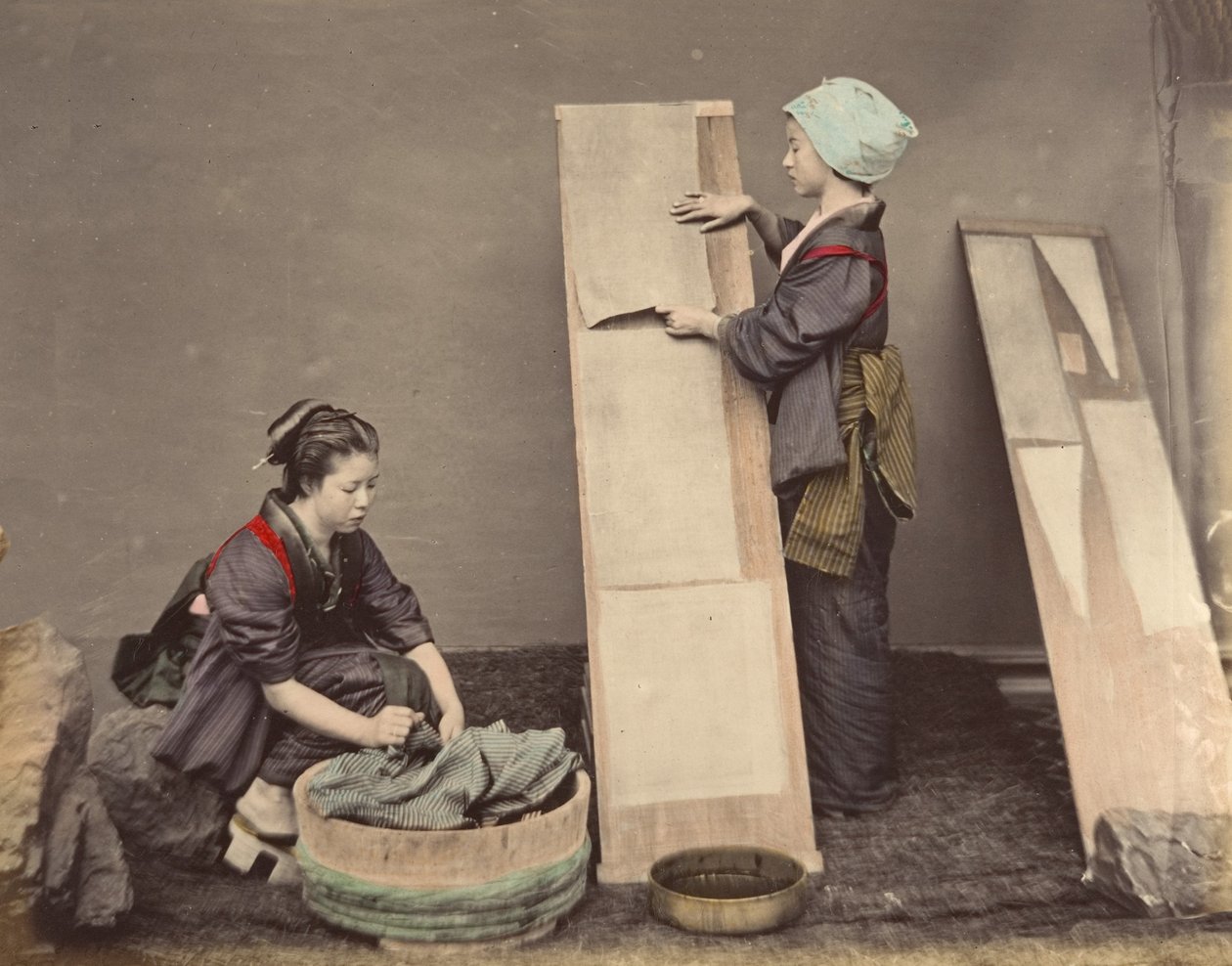 [两名日本妇女与衣物摆放在一起]，1870年代。 作者 不明