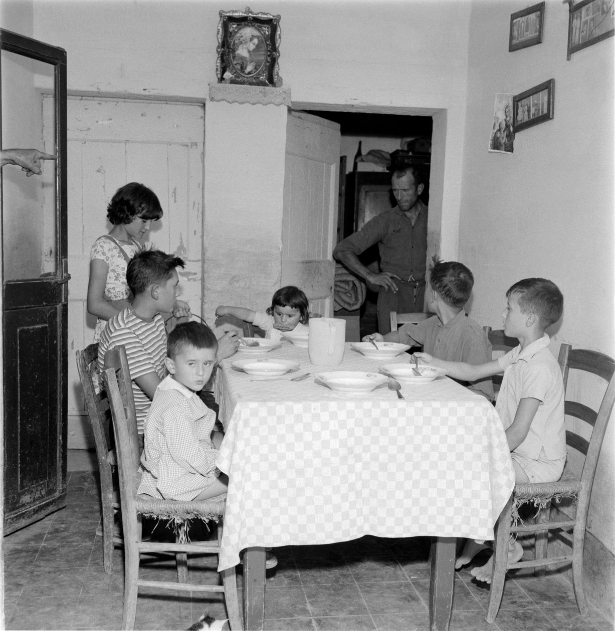 大家庭在乡间别墅餐厅的餐桌上团聚。 1960年代 作者 不明