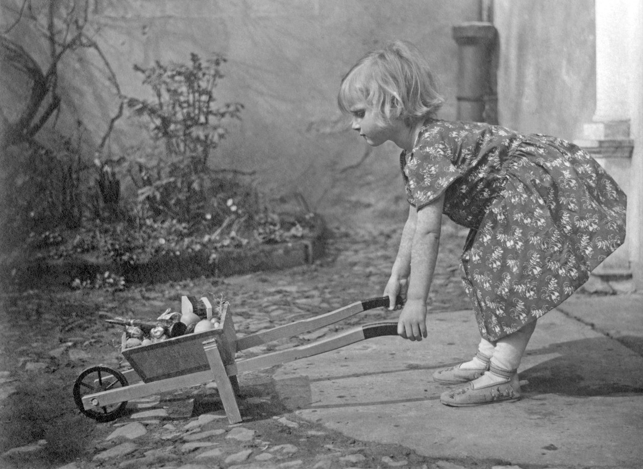 小女孩玩独轮车。 1931 年左右的摄影 作者 不明