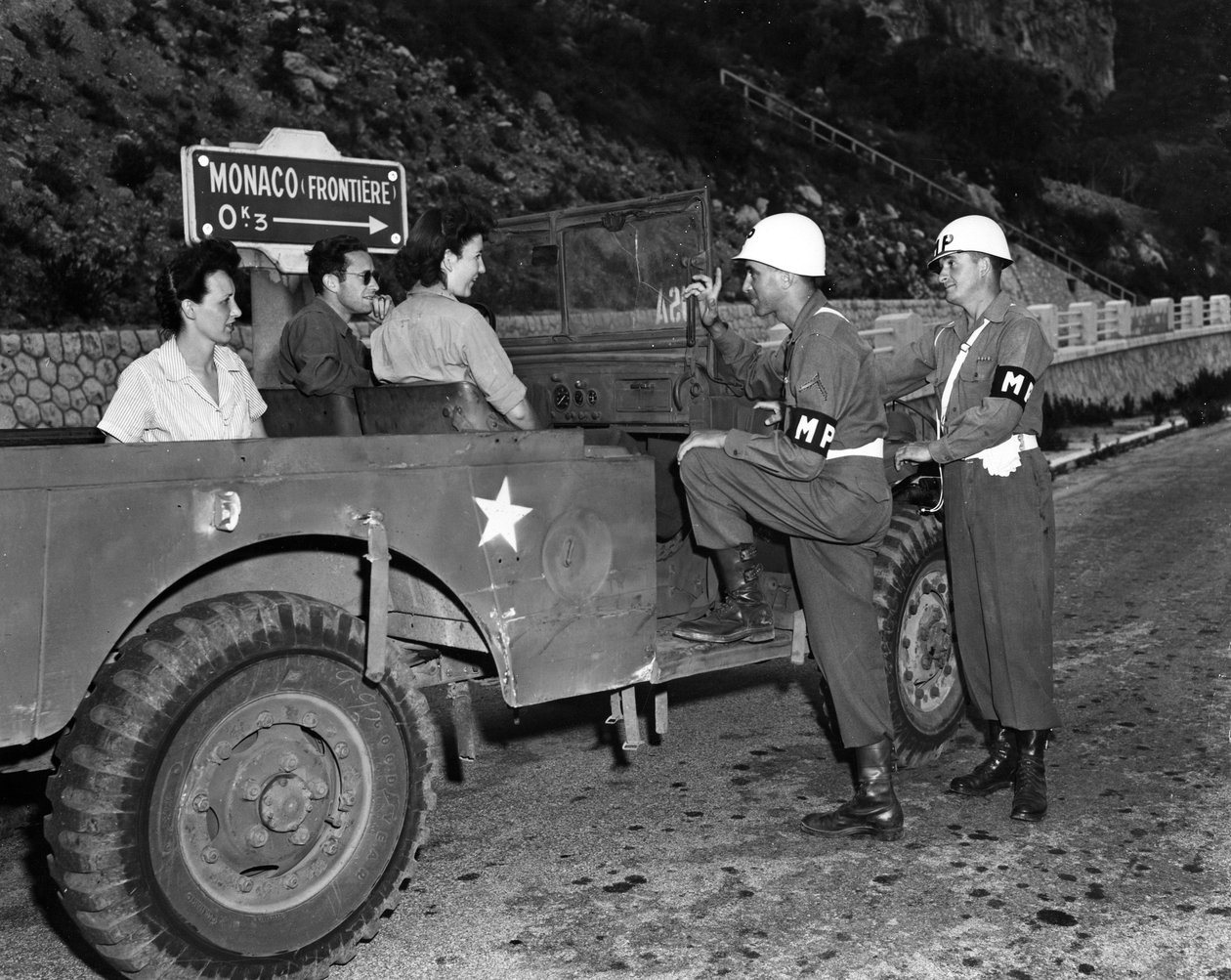 第二次世界大战（1939-1945） - 第二次世界大战（WWII 或 WW2）：摩纳哥法国里维埃拉附近 1945 年 6 月 30 日：美国里维埃拉游乐区 (USRRA) 的两名 Wacs 和客人与两名驻扎的美国陆军宪兵讨论 在 Mone 的边缘 作者 不明
