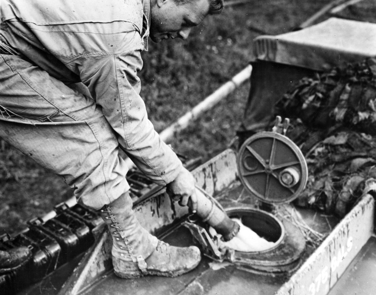 World War II (WWII) (1939-1945) - World War II (WWII or WW2): Normandy (France) Summer 1944: 在一个储气站，美国运输公司的一名士兵为 GMC 油轮的油箱加油 作者 不明