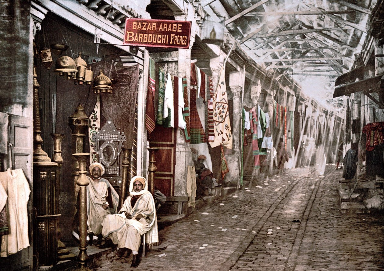 突尼斯的Le souc el Trouck：有法语标志的商店 "Bazaar arabic Barbouchi brothers"。1900年彩色照片。 作者 未知艺术家