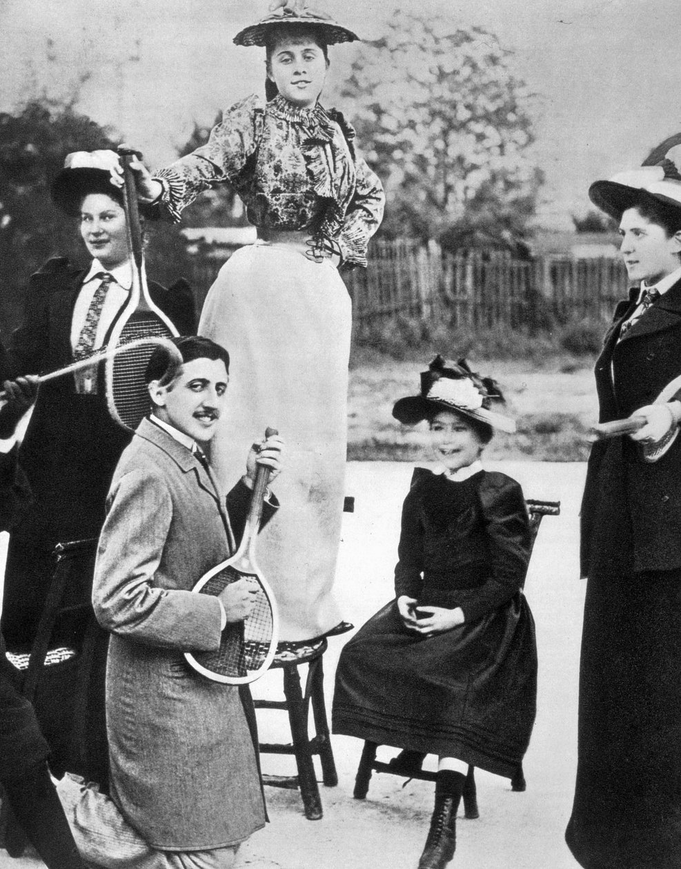 Marcel Proust, in the midst of a group of young women, playing guitar on a tennis racket at Bineau Boulevard in Paris 作者 未知的摄影师