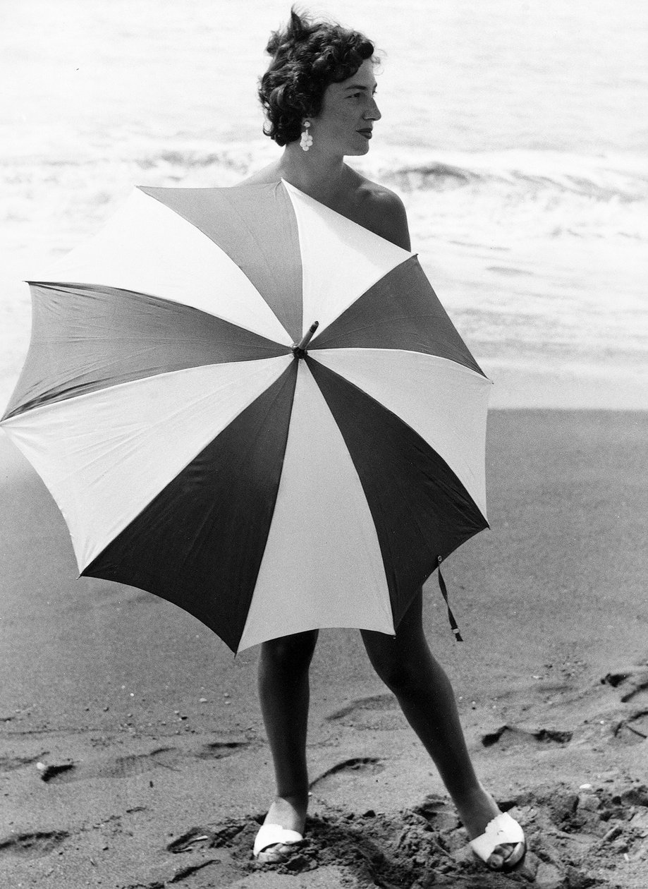 海滩上撑伞的女人，约 1960 年（黑白照片） 作者 文森佐·巴洛基