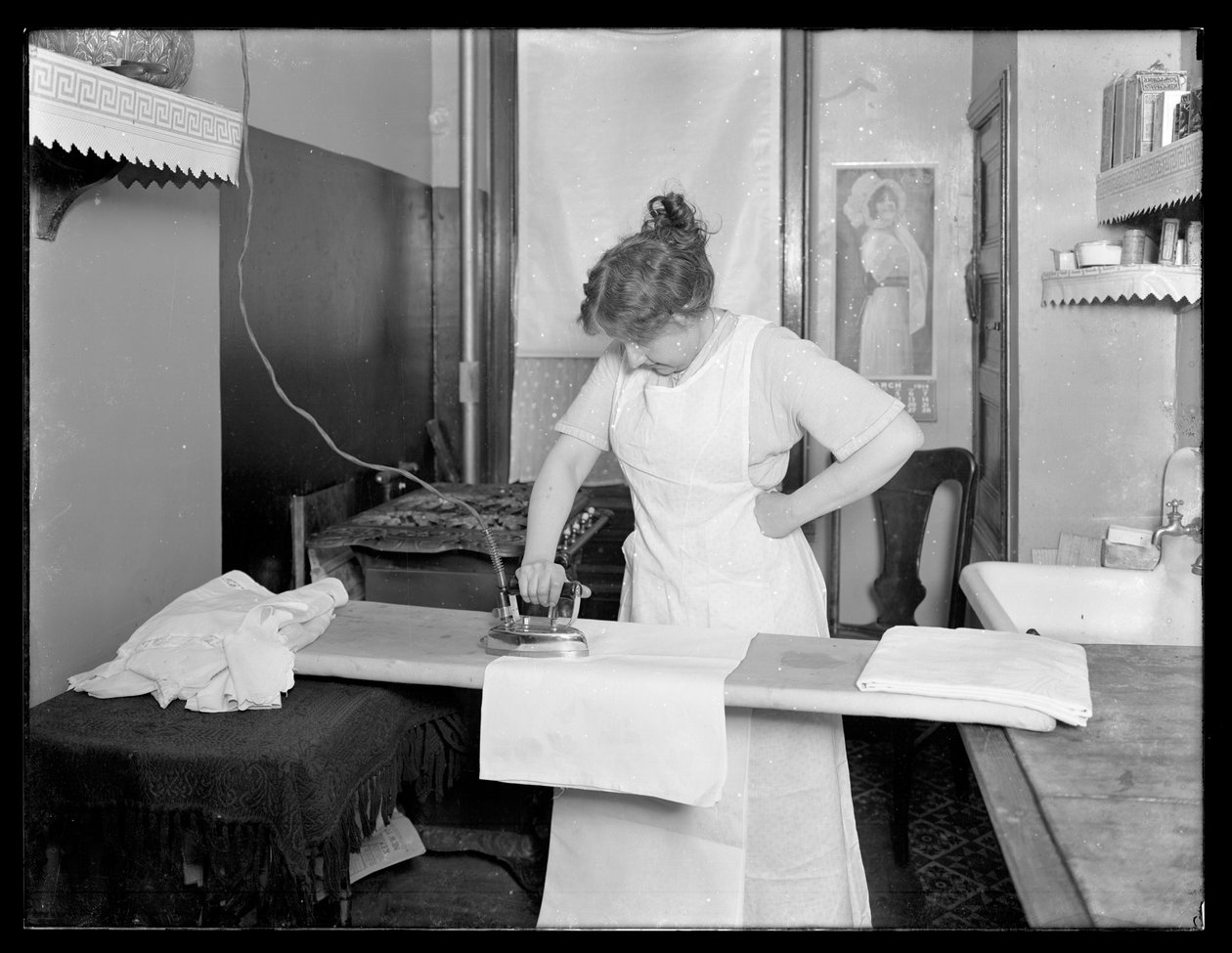 证明使用电熨斗c.1913-14的未认出的妇女 作者 威廉·戴维斯·哈斯勒