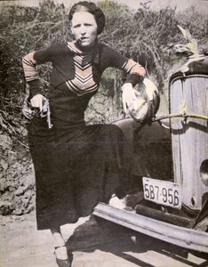 邦妮-帕克拿着枪和雪茄摆出 "强硬 "的姿势，约1934年（黑白照片）。 作者 美国摄影师
