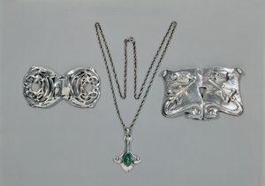 为Liberty设计的银首饰。从左到右：腰部搭扣采用交错式凯尔特设计，1904年。吊坠和链条镶嵌凸圆形切割的绿玉髓。腰部扣与repousse设计锤打