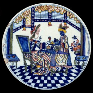 代尔夫特瓷盘，表现一个女人在她的黑人仆人服务的桌子上。1705年塞夫勒，国家陶瓷博物馆 作者 荷兰学校