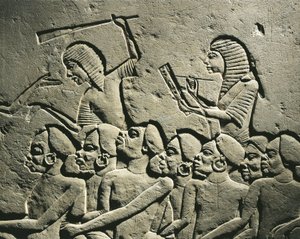 一群黑人囚犯被手持棍棒的卫兵包围，一名抄写员正在起草报告。萨卡拉霍伦赫布墓的浮雕，细节 作者 埃及第十八王朝
