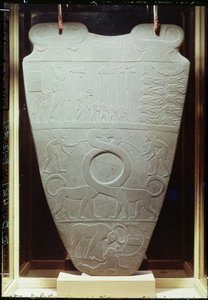 Narmer调色板：仪式调色板描绘了King Narmer，穿着下埃及的红色皇冠，检查绑定和被斩首的囚犯，还有一对巨型长颈猫，在Hieraco找到