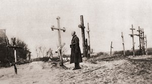 1915年，一名俄罗斯士兵在第一次世界大战期间战友的坟墓中，来自“插图战争新闻” 作者 英国摄影师