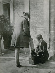 发光的年轻鞋油供以人员在街道上的鞋子 作者 英国摄影师