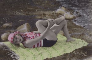 女孩躺在海滩上的毛巾（彩色照片） 作者 英国摄影师