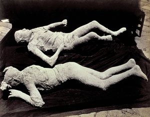 Two casts of human figures from the excavations of Pompeii. The exhibits were placed on black cloth in order to photograph them 作者 乔治·夏