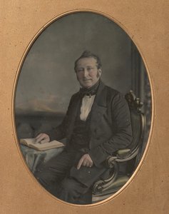 坐着的人指着一本打开的书中的一段话，1850年代。