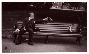 Man on a park bench, c 1920 A snapshot photograph of a man sitting on a park bench, feeding pigeons, taken by an unknown photographer in about 1920 作者 不明