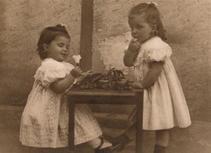 1937年，两个坐在桌子旁的年轻女孩。 作者 不明