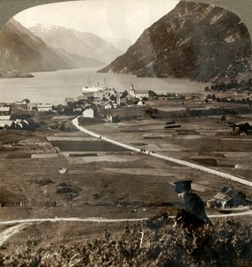 1905年，挪威北部奥德的村庄屋顶和阳光明媚的田野，穿过狭窄的山壁索夫峡湾。 作者 不明