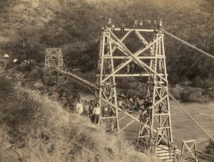 加利福尼亚州弗雷斯诺：1890年 这张由C.C.柯蒂斯拍摄的照片显示了横跨国王河的史密斯和摩尔桥，这是海勒姆-史密斯和奥斯汀-D.摩尔建造的水槽的一部分，用于为他们的公司--国王河木材公司从锡耶拉山脉运输木材。 作者 不明