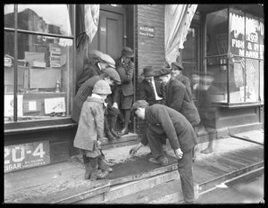 1915年5月30日，纽约市，一个不明身份的男孩在弯腰上拍摄掷骰子