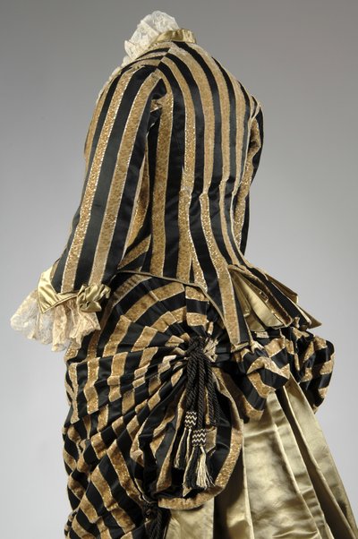 晚礼服，c.1884（背面斜视图）。 丝缎和剪裁天鹅绒、蕾丝、丝线流苏和流苏。 查尔斯·弗雷德里克·沃思，法国。 作者 查尔斯·弗雷德里克·沃思