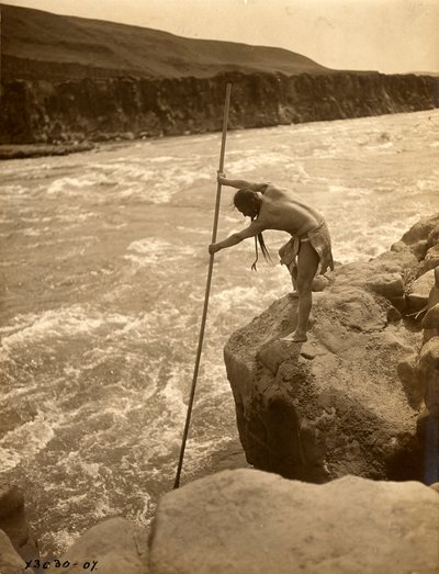特拉克卢伊特印第安人，站在岩石上，用浸网捕鱼，约 1910 年（黑白照片） 作者 爱德华警长柯蒂斯