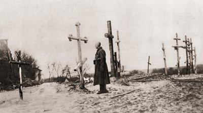 1915年，一名俄罗斯士兵在第一次世界大战期间战友的坟墓中，来自“插图战争新闻” 作者 英国摄影师