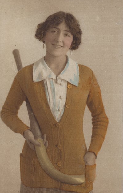 Pretty girl, in knitted jumper, with pearl earrings, holding hockey stick (photo) 作者 English Photographer
