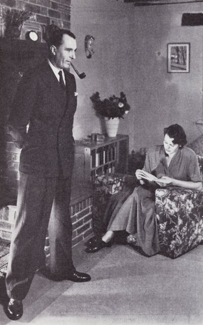妻子念书，而丈夫为火取暖，约于1950年 作者 英国摄影师
